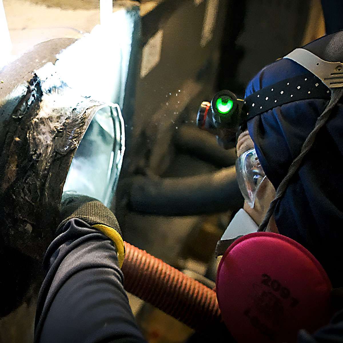 Air Quality Express technician in respirator cleaning mold from an air duct in Houston